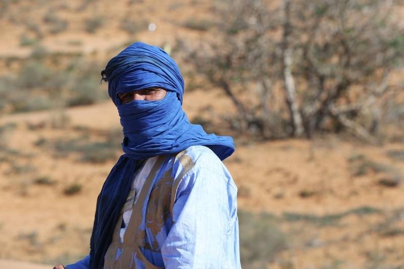 Person wearing traditional desert attire in Sahara environment featured during 10 Days tour from Tangier cultural travel experience.