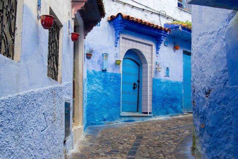 Blue painted street in Chefchaouen medina with traditional buildings featured during 12 days tour from tangier to marrakech.