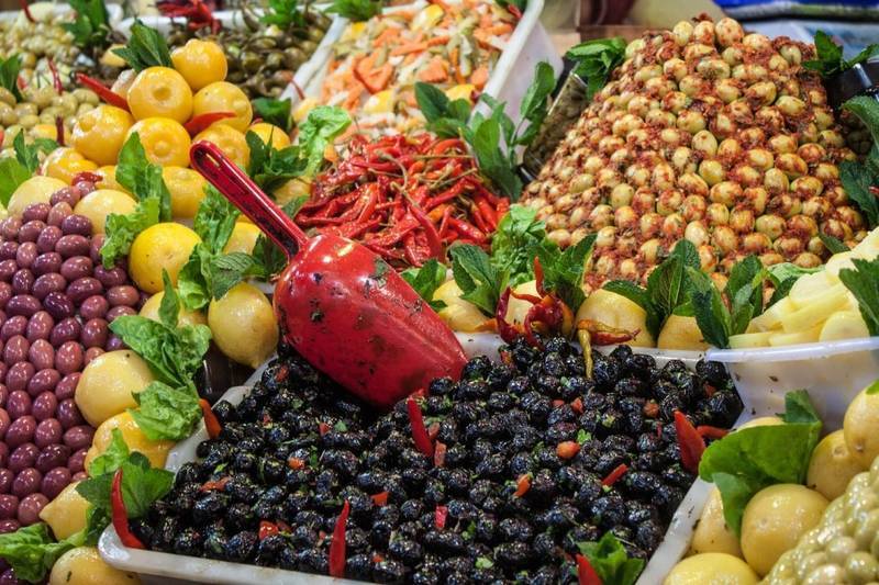 Traditional Moroccan food display in a lively souk market with local products featured during moroccocameltrips cultural travel experience.