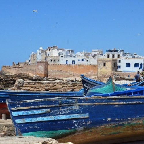 Historic port of Essaouira with calm coastal scenery and boats featured during 12 days tour from tangier to marrakech.