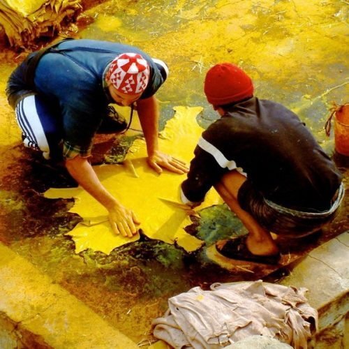Artisans working at Chouara Tannery in Fes with dye pits featured during the Casablanca to Marrakech 10 days tour.